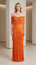 Front view of woman wearing orange off-shoulder beaded fringe evening gown