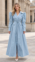 Front full view of light blue puff shoulder maxi trench coat tied at the waist