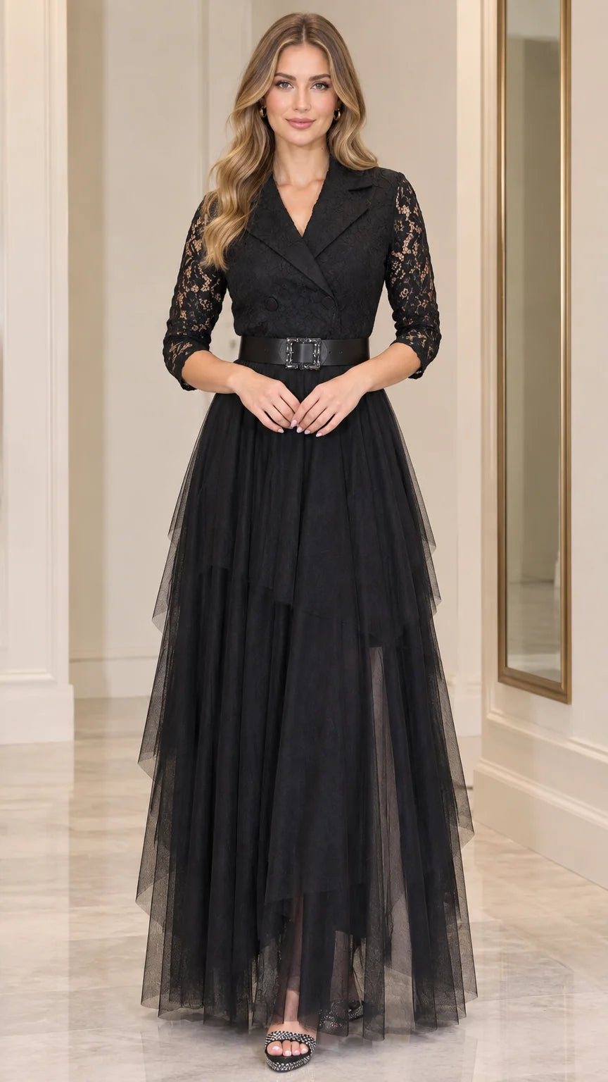 Front full-length view of model wearing black tuxedo lapel lace tiered maxi evening dress