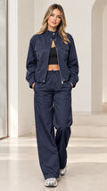 Front full-length view of woman wearing navy blue zip-up jacket and wide-leg tracksuit set