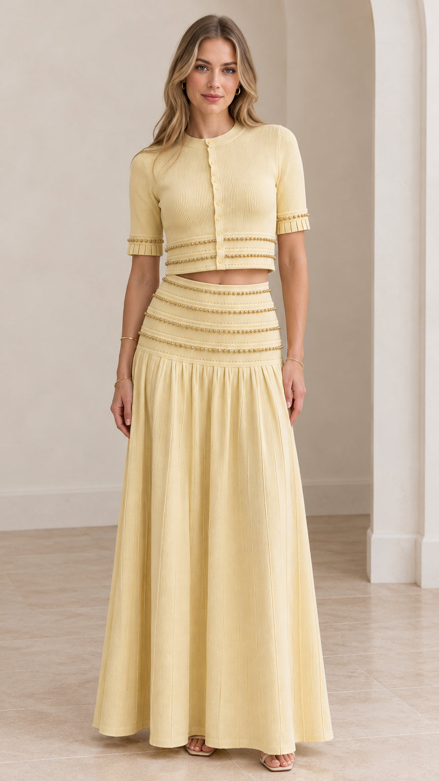 Model wearing butter yellow beaded crop top and pleated maxi skirt set front view