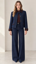 Front view of model wearing Indigo Blue denim jacket and wide-leg pant set with brown contrast trim