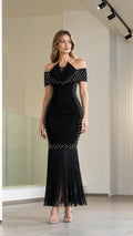 Front view of model wearing black off-the-shoulder pearl embellished fringe maxi evening dress