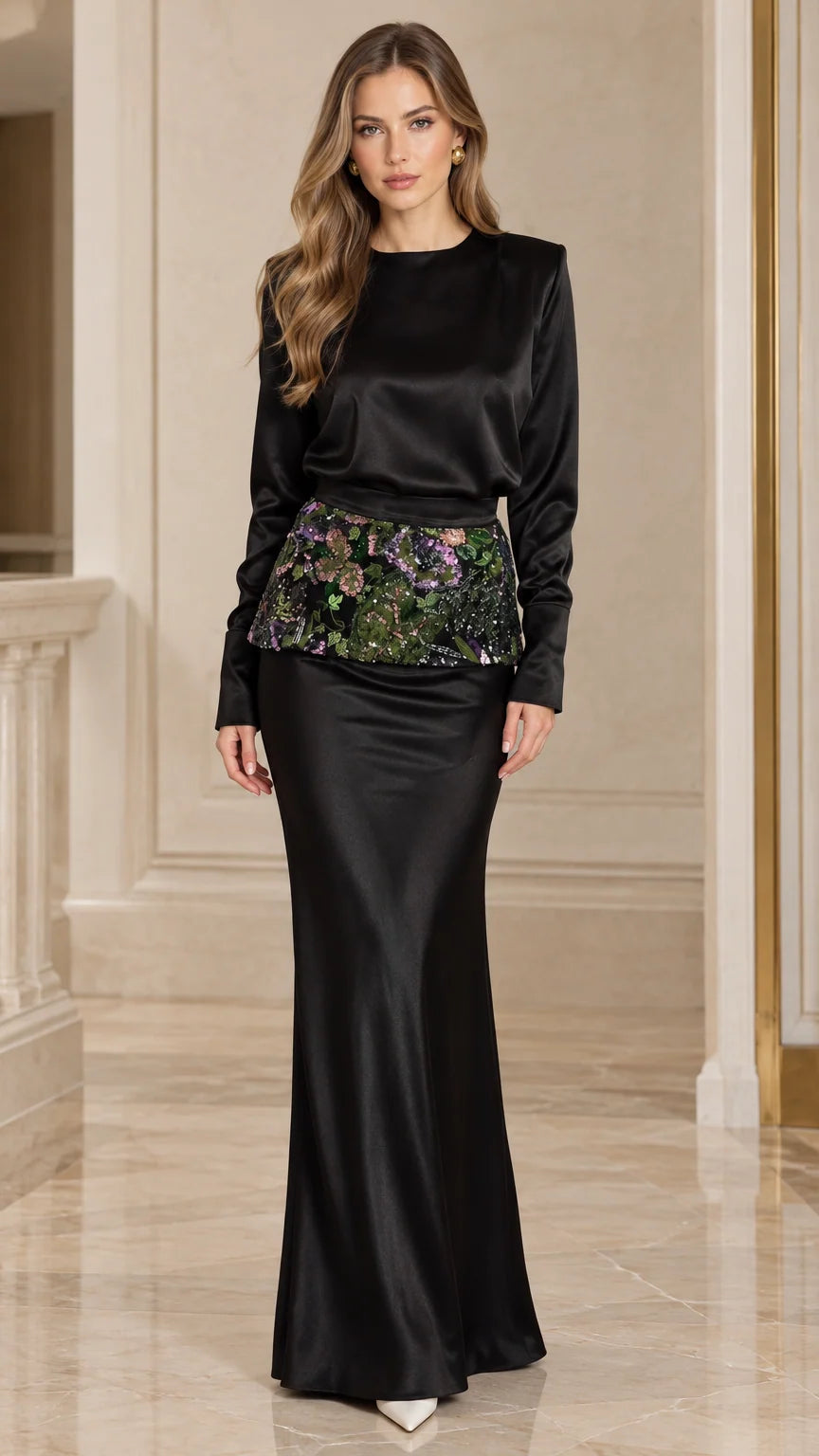 Front full-length view of woman wearing black long sleeve satin evening maxi gown with floral embroidered waist