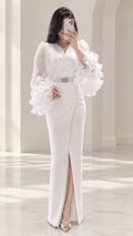 Front full view of white long sleeve maxi evening gown with ruffle cuffs and crystal belt