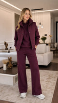 Front view of model wearing burgundy 3-piece tracksuit set with padded vest, hoodie, and wide-leg pants
