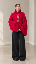 Front full view of woman wearing red zip-front batwing sleeve cardigan with black wide leg pants
