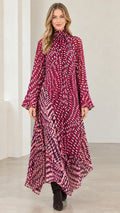 Front view of model wearing magenta abstract print high neck asymmetrical maxi dress