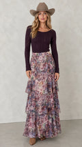 Front view of woman wearing Mauve Plum tiered floral maxi skirt with plum long sleeve top and hat