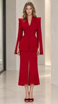Front full view of woman wearing red tailored peplum blazer and matching lace midi skirt