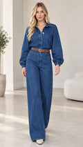 Front view of model wearing medium blue wide-leg denim jumpsuit with brown belt