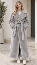 Front full-length view of woman wearing grey plush teddy wrap maxi coat with tie belt