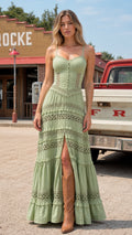 Front view of model wearing Sage Green corset bodice tiered lace maxi dress with cowboy boots