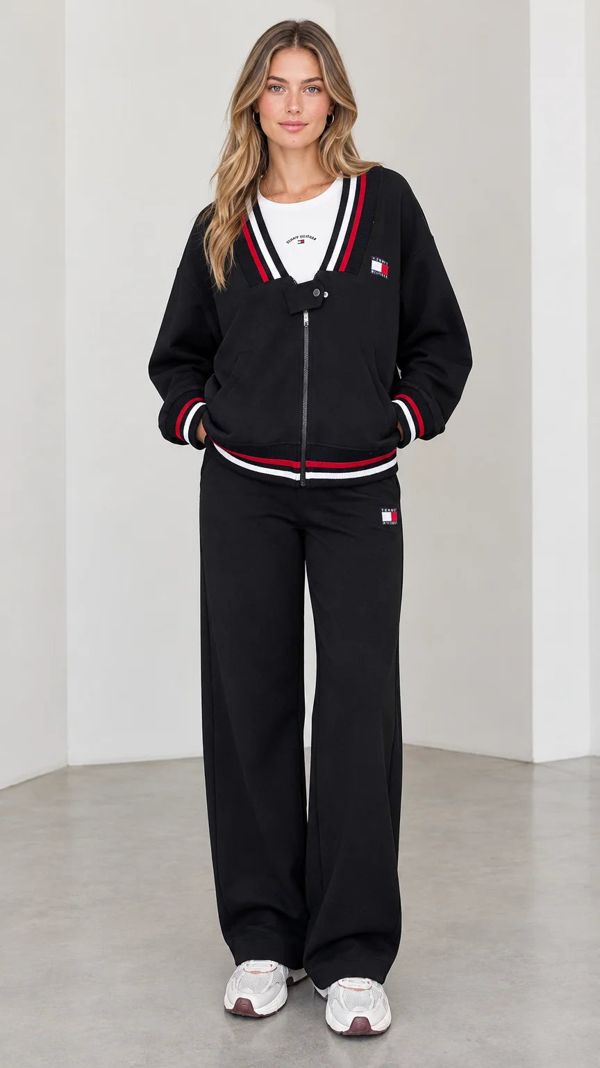 Full front view of model wearing black varsity striped zip jacket and wide leg sweatpants set