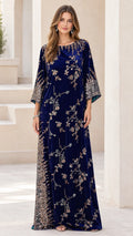 Front full-length view of woman wearing navy blue embellished velvet kaftan maxi dress