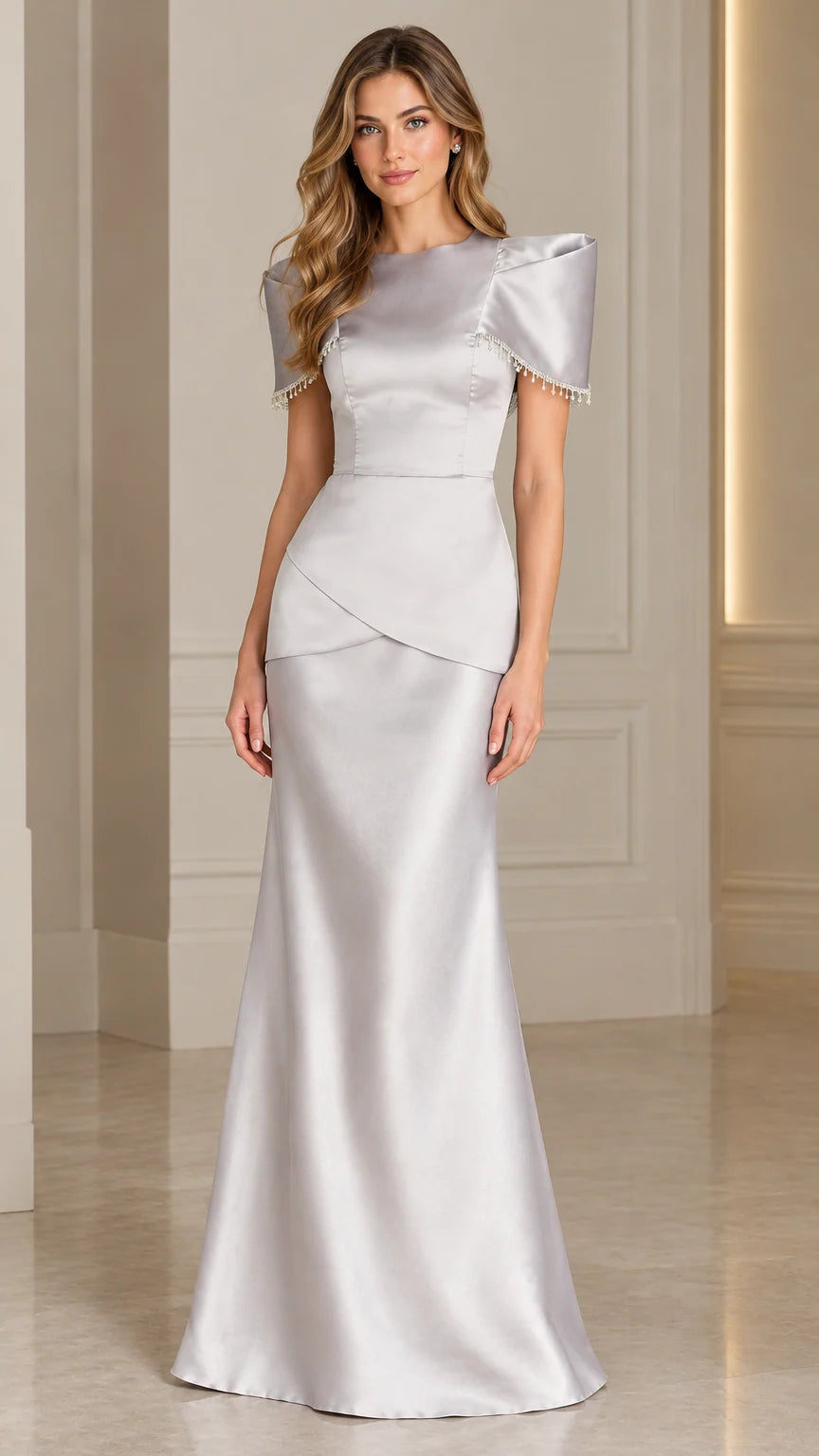 Front view of model wearing floor-length silver satin evening gown with beaded fringe sleeves