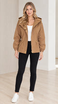 Front view of model wearing camel hooded drawstring utility jacket with black pants