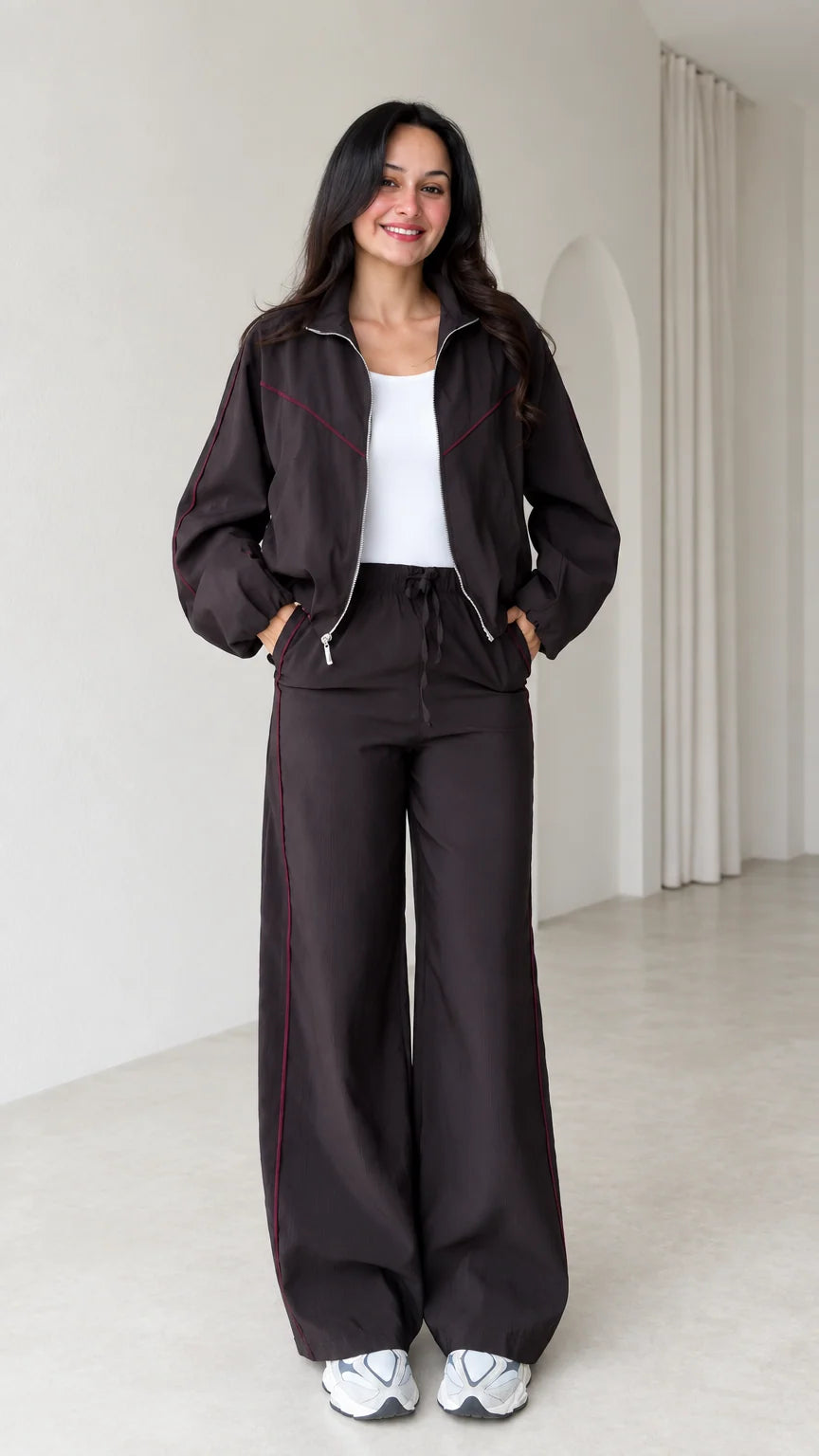 Front view of model wearing dark brown zip track jacket and matching wide leg pants set