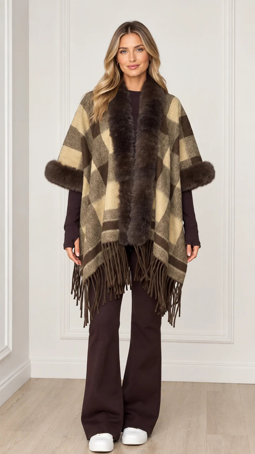 Woman wearing olive khaki plaid poncho with faux fur collar and fringe hem - front view