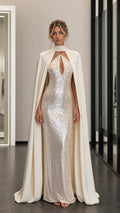 Front view of model wearing champagne sequin evening dress with attached cape