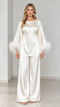 Model wearing ivory satin two-piece set with feather trim cuffs front view