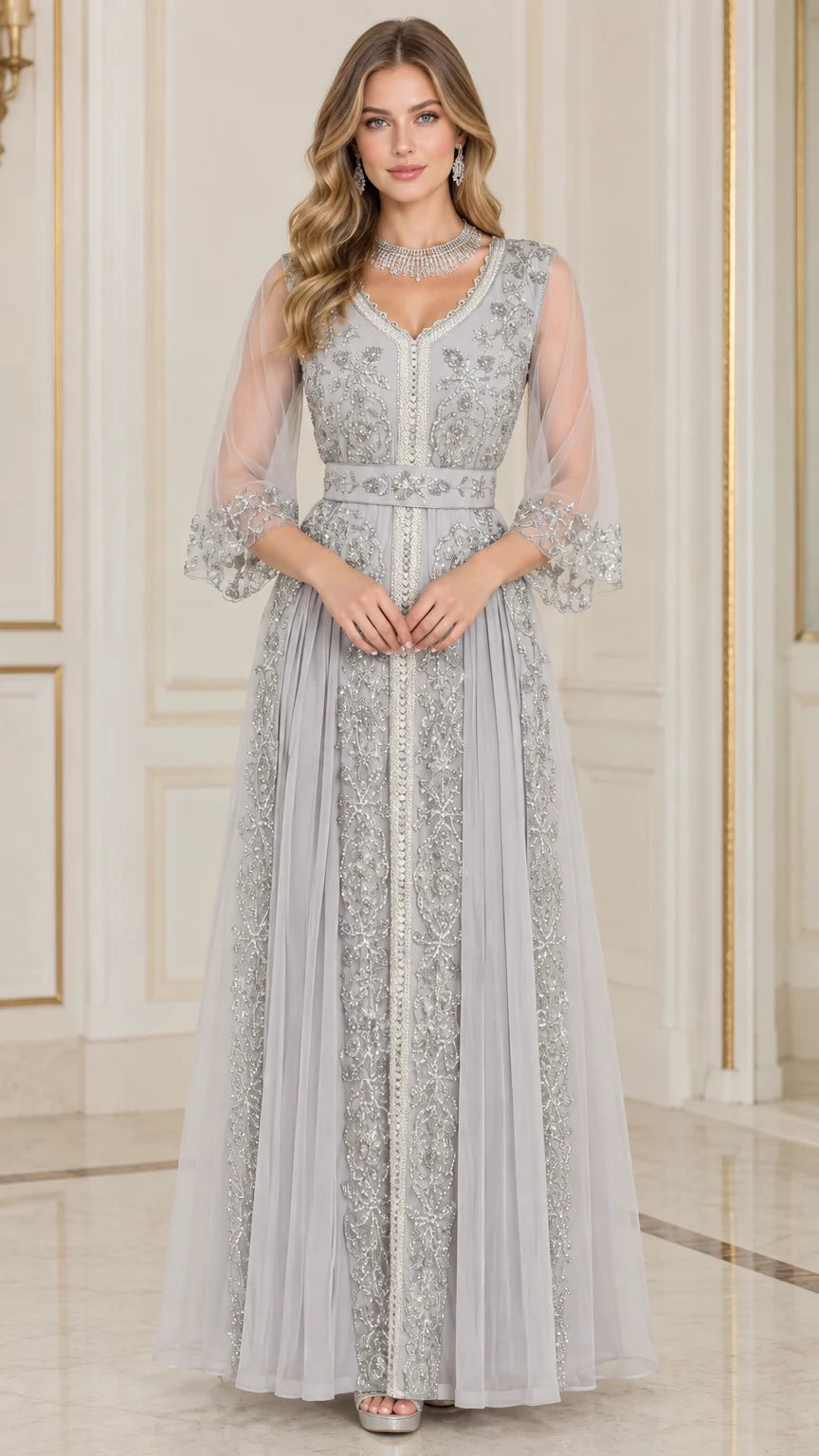 Front full-length view of woman in silver grey embroidered beaded V-neck evening gown