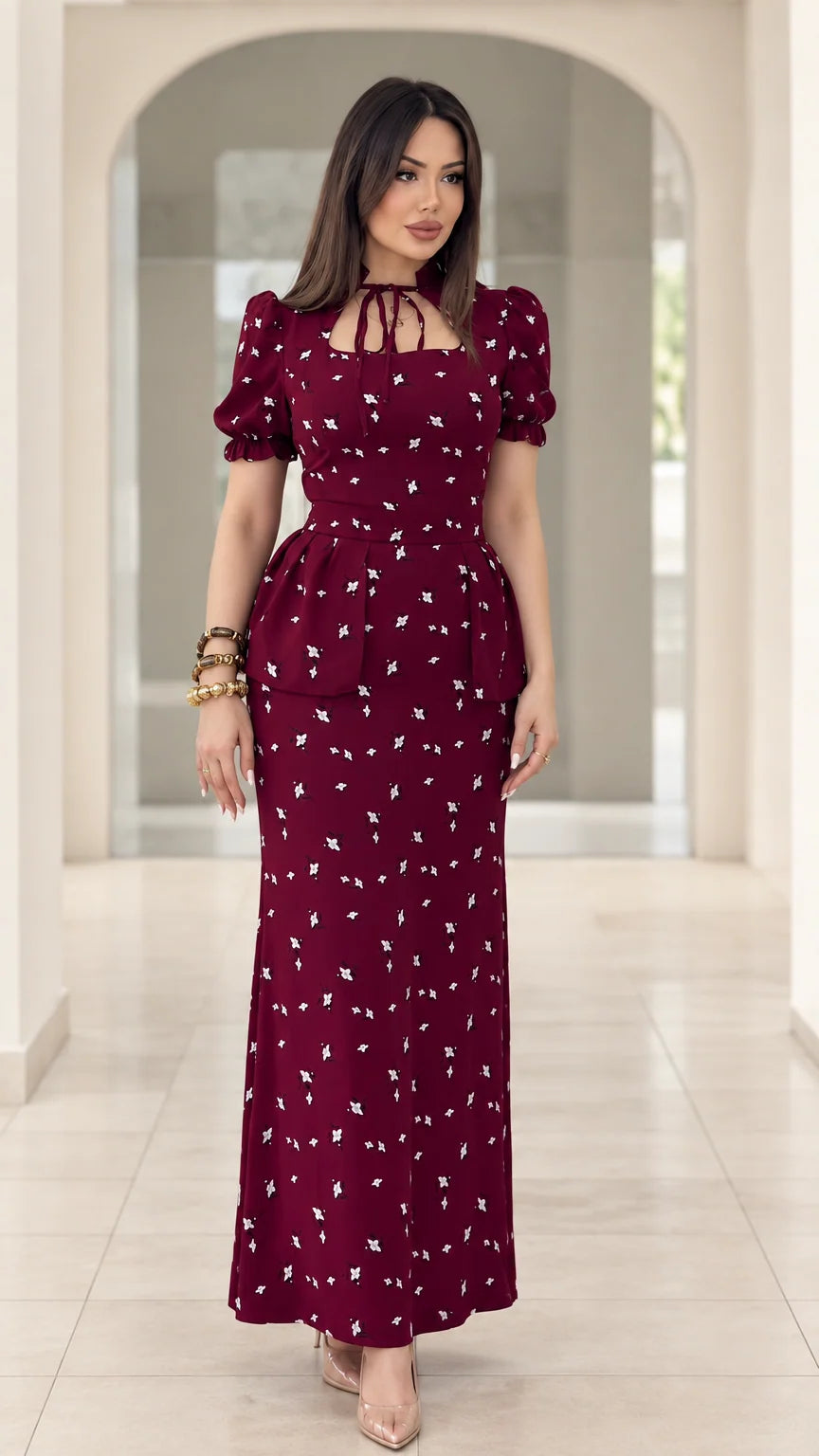 Front view of model wearing burgundy floral print peplum maxi dress with puff sleeves