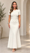 Model wearing cream two-piece knit top and ribbed maxi skirt set front view