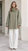 Front view of model wearing Sage Green high-neck belted trench jacket with white trousers