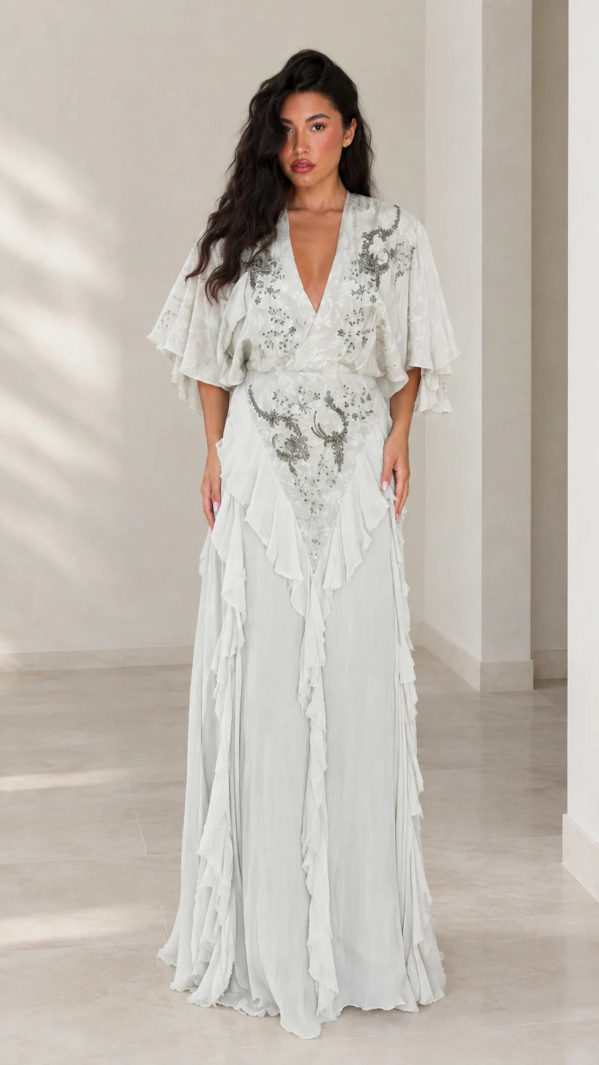 Front view of woman wearing elegant ice blue embroidered flutter sleeve maxi dress