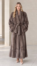 Front view of woman wearing taupe maxi faux fur wrap coat with tie belt