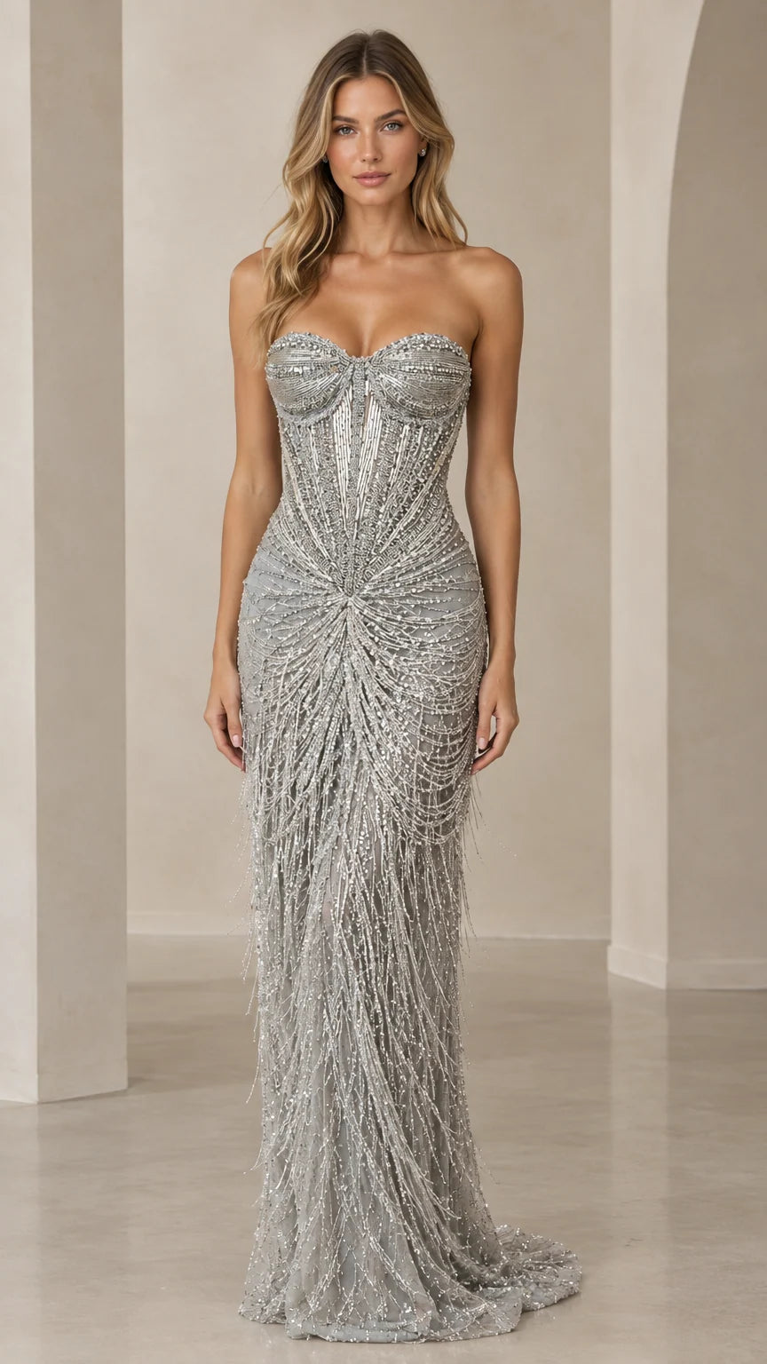 Front view of model wearing a floor-length strapless silver beaded fringe evening gown