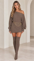 Model wearing taupe off the shoulder ribbed knit mini sweater dress with chain belt and thigh high boots front view