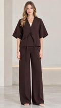 Front view of woman wearing chocolate brown tie-front short sleeve top and wide-leg pants set
