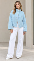 Front full-length view of woman wearing Light Blue stand collar snap jacket and white wide-leg trousers