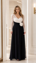 Front view of woman wearing two-tone white sequin bodice and black chiffon skirt evening gown with 3D waist flower