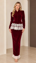 Front full-length view of model wearing burgundy velvet peplum maxi dress with white lace trim