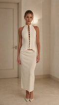 Model wearing ivory crystal embellished halter top and midi skirt set from front