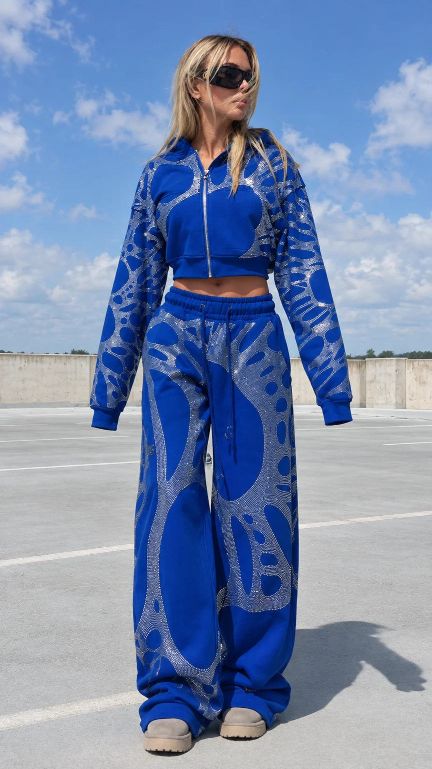 Model wearing royal blue rhinestone cropped hoodie and wide leg sweatpants tracksuit set front view