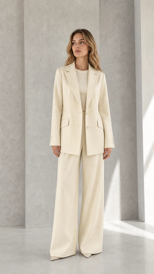 Front view of woman wearing cream tailored blazer and wide-leg trousers suit set