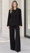 Front full-length view of model wearing black tailored blazer and wide-leg trousers suit set