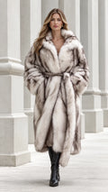 Full front view of model wearing a long Silver Frost belted chevron faux fur coat with black boots