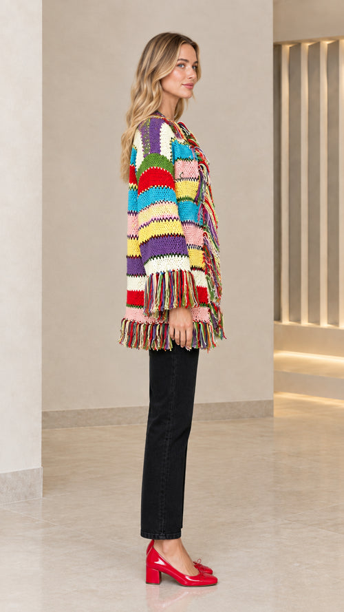 Side profile view of model wearing colorful striped tassel open-front cardigan