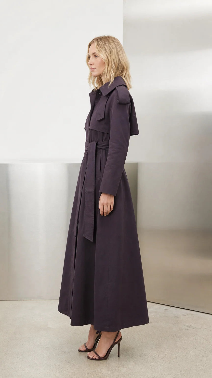 Side profile view of deep purple maxi trench coat showing structured length and lapel