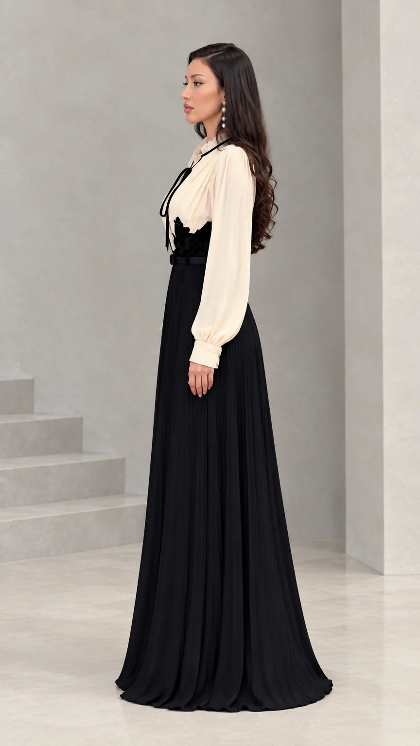 Side profile view of cream and black long sleeve pleated maxi dress