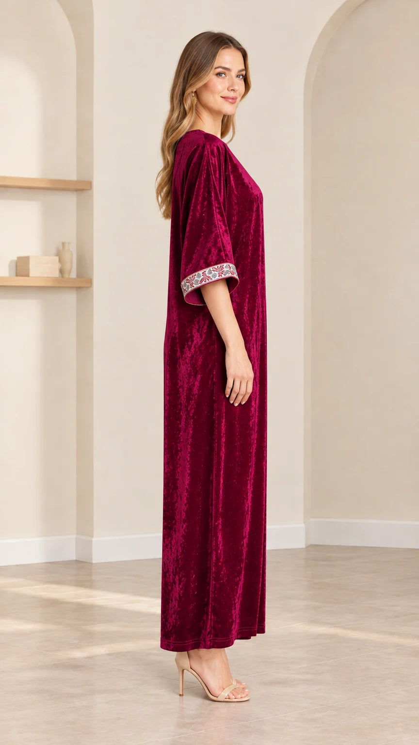 Side profile view of model in burgundy velvet kaftan dress
