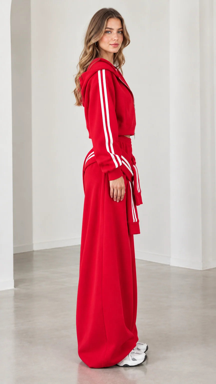Model wearing red cropped hoodie and wide-leg sweatpants set side view