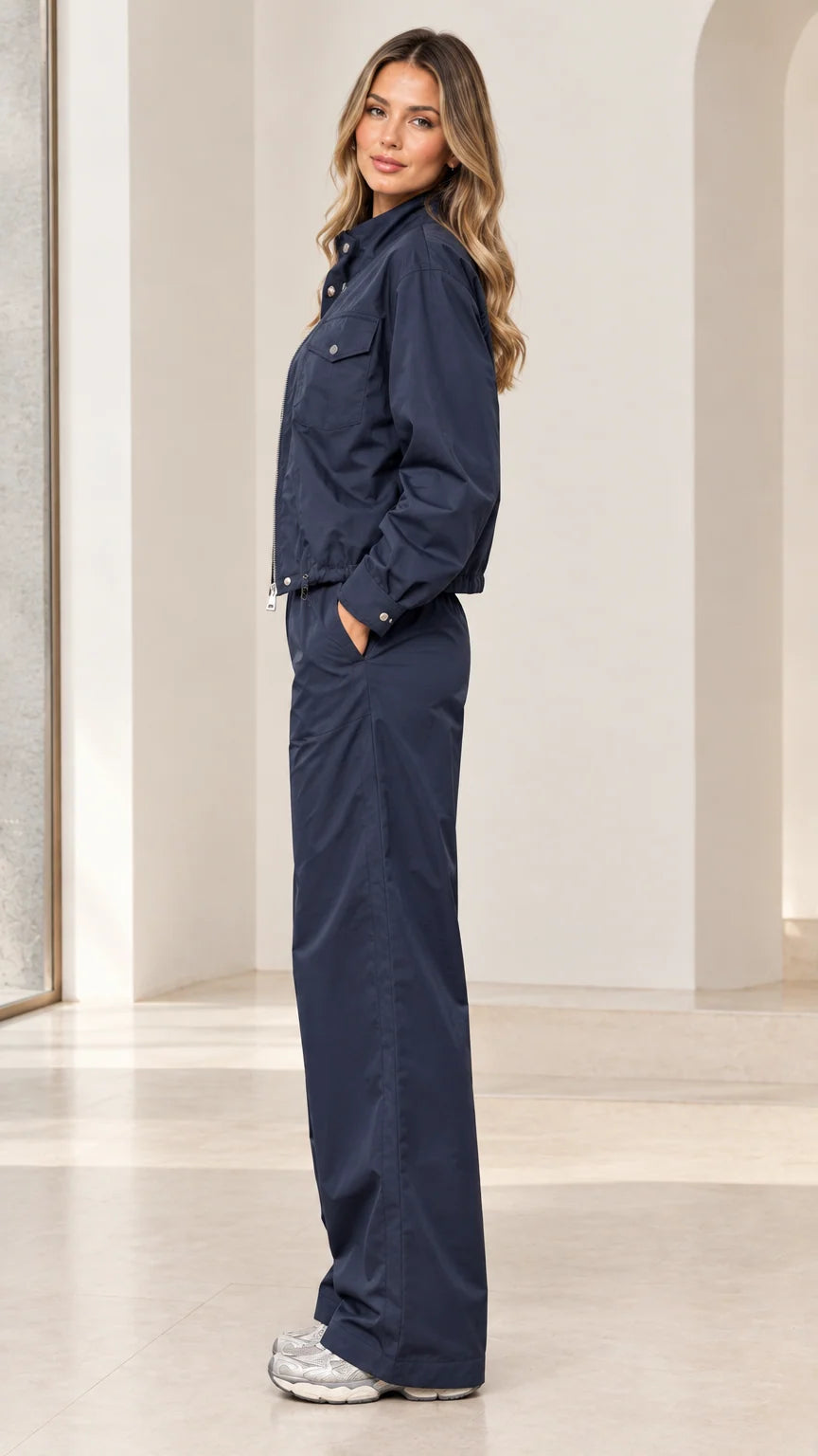 Side profile view of woman wearing navy blue windbreaker two-piece set