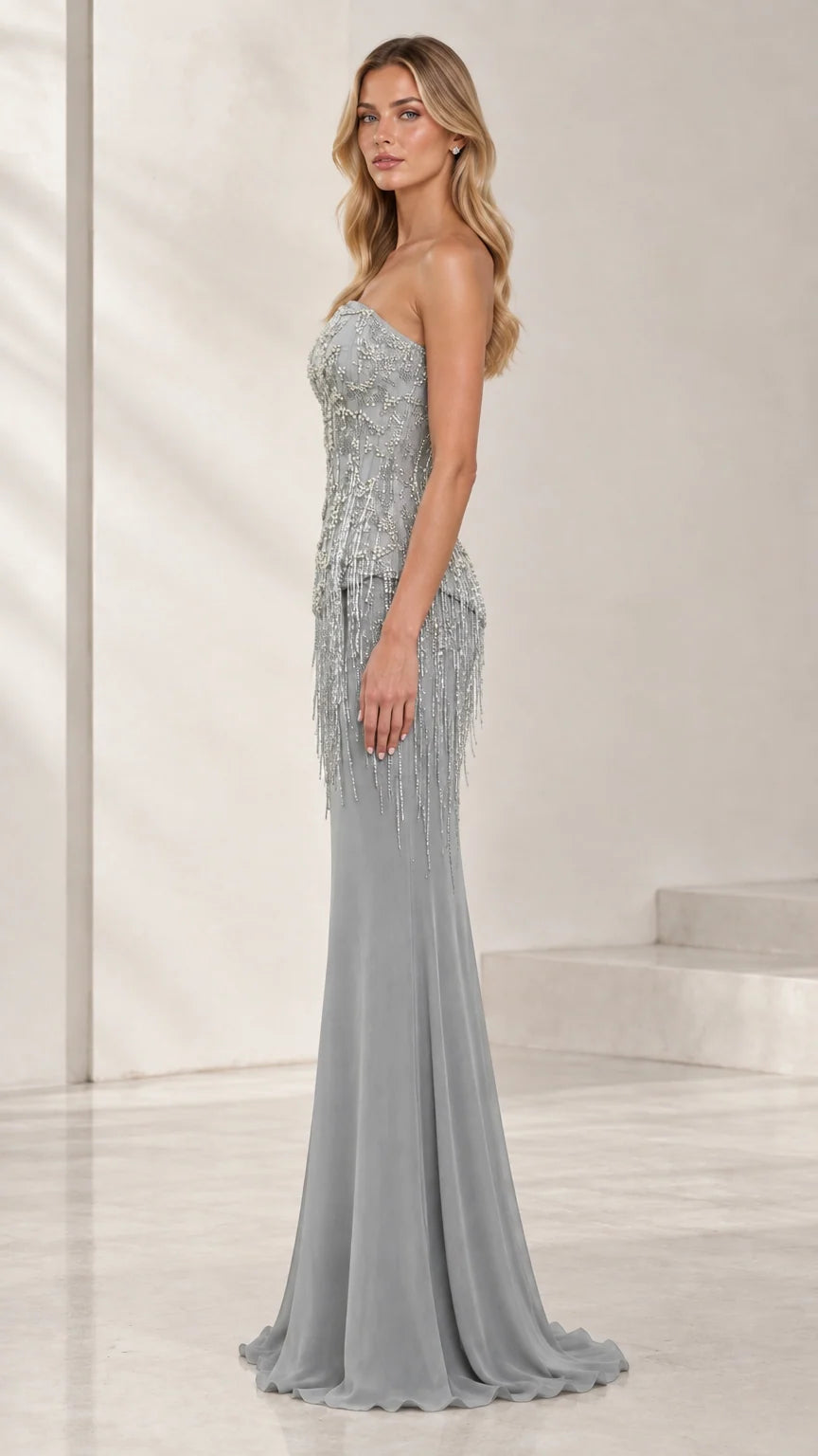 Side profile view of strapless silver gray beaded gown with fringe details