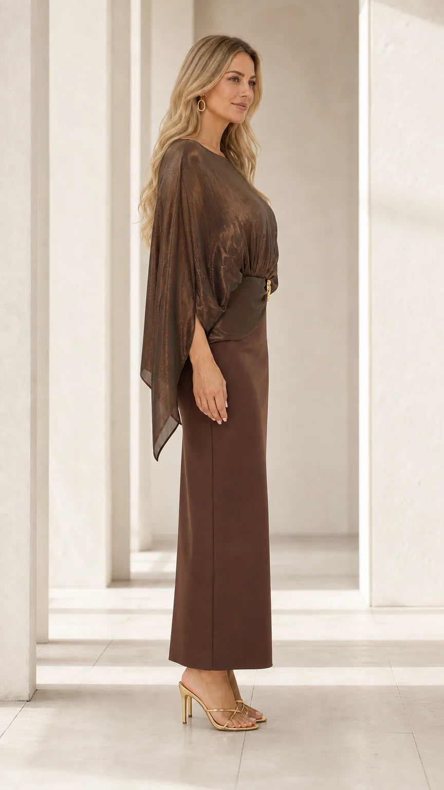 Side profile of woman wearing bronze brown cape overlay column evening gown